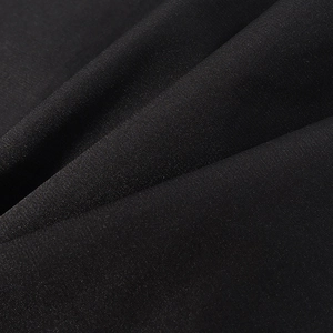 Detailed macro view of premium black textile fabric with fine texture and subtle luster