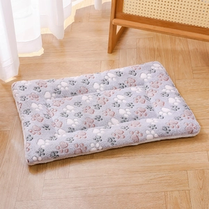 Close-up of thick plush pet mat with cute paw prints on warm wooden floor