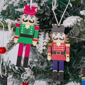 Nutcracker Christmas tree hanging ornaments on snowy branches in red and green colors