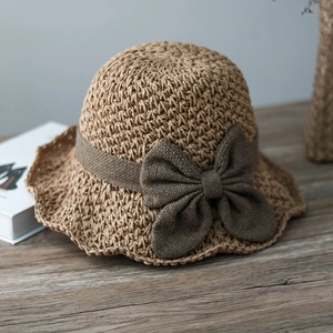 Close-up of the fine straw weave and decorative brown bow on this stylish sun hat