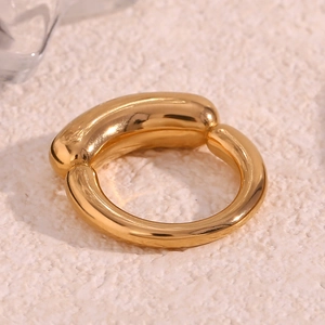 Detailed close-up of a minimalist 18K gold-plated thick band ring on beige texture