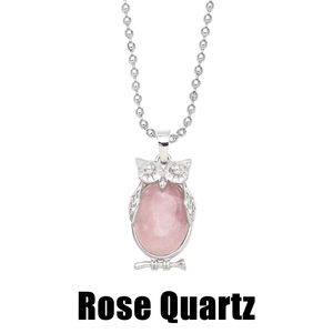 Detail view of pink rose quartz gemstone inlaid in a vintage silver owl pendant necklace