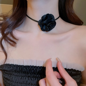 Close-up of a French vintage black fabric rose choker necklace worn on neck