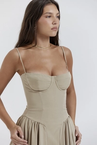Detail of khaki corset-style sun dress featuring a cinched waist and pleated puff hem