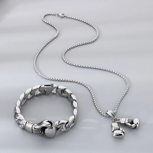 Detail of silver stainless steel Cuban chain bracelet and boxing glove pendant set
