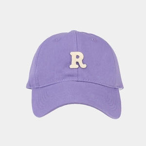 Dettaglio del cappellino da baseball viola con ricamo 3D della lettera R in rilievo