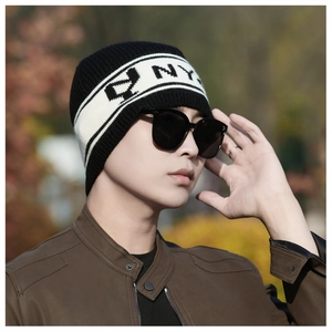 Détail du bonnet en tricot avec rayures noires et blanches et motif NY tissé brodé