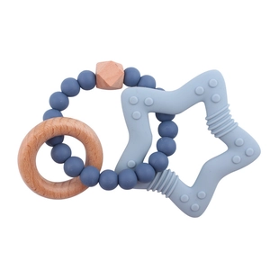 Detail of star-shaped silicone teether with wooden ring and navy blue beaded bracelet