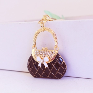 Sparkling rhinestone bow handbag keychain in black and gold finish for women