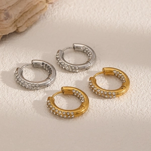 Vue détaillée de boucles d'oreilles créoles dorées et argentées serties de zircons