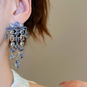 Detail von eleganten Silber-Quastenohrringen mit blauen und klaren Zirkonsteinen
