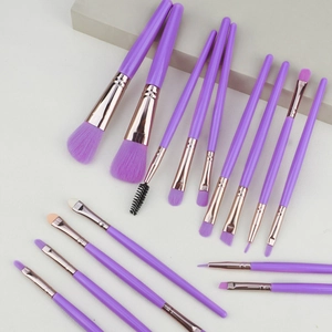 Close-up of 15-piece purple makeup brush set with rose gold ferrules on stone props