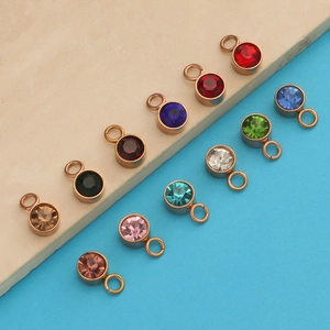 Close-up of multicolored round crystal birthstone pendants with gold metal base loops