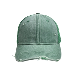 Detalle macro del algodón lavado desgastado y malla transpirable en gorra verde retro