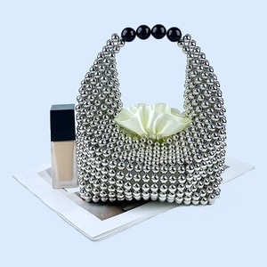 Close-up of silver beaded pillow bag featuring black handle beads and satin inner pouch