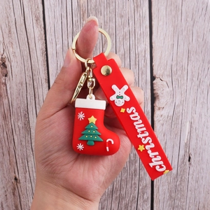 Detail of red Christmas stocking keychain with silicone strap and festive relief text