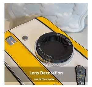 Close-up of camera-style PU leather crossbody bag with 3D lens and contrast stitching