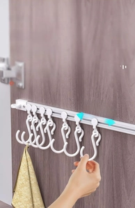 Kitchen cabinet sliding rail hook detail showing adjustable white S-hooks for storage