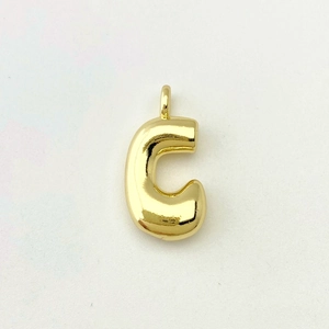 Close-up of golden balloon-style alphabet C pendant with a smooth polished finish