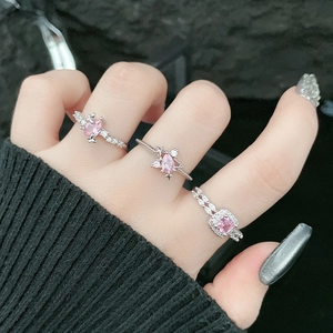 Detailed view of silver rings featuring pink zircon stones and butterfly patterns