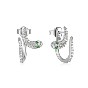 Macro shot of 925 sterling silver snake earrings with white zircons and green gem eyes