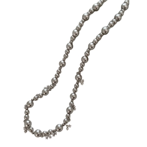 Elegant vintage necklace with grey pearls and sparkling zircon flower charms on white background