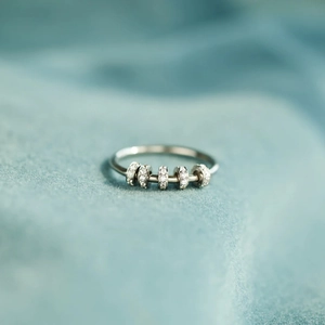 Macro shot of silver fidget ring with five sliding colorful cubic zirconia stones