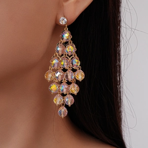 Close-up of colorful crystal tassel earrings with gold base on a female model