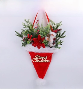 Detail of Christmas hat wall hanging with pine branches, berries and Santa doll