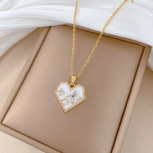 Elegant gold titanium heart necklace with white enamel and sparkling zircons in a box