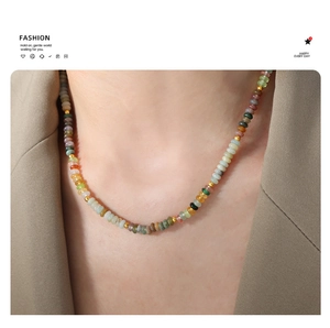 Colorful beaded necklace with golden spacers on a model in a minimal chic blazer
