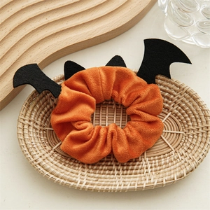 Vue détaillée du chouchou d'Halloween avec ailes de chauve-souris en velours orange