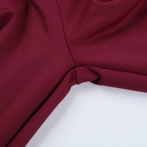 Gros plan d'une combinaison rouge foncé montrant les détails de couture et de tricot