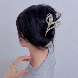 Elegant gold metal tulip hair claw clip with pearls shown on model's hairstyle