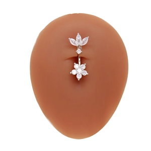 Détail du piercing de nombril fleur en argent avec zircon sur modèle de ventre