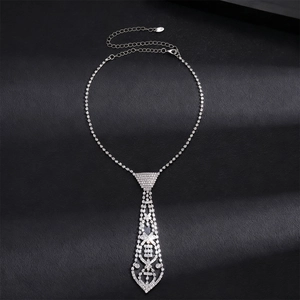 Gros plan d'un pendentif en forme de cravate serti de strass sur fond noir texturé
