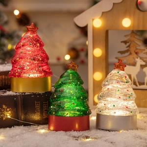 Lighted mini Christmas trees with colorful sequins and star toppers in a winter scene