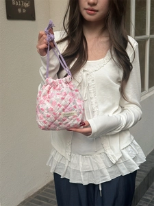Close-up of pink quilted floral drawstring storage bag with delicate embroidery detail