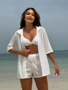 Detail of the white knitted fabric texture on three-piece beach bikini and cover-up set