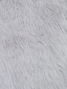 Macro consistenza di morbida ecopelliccia grigia con fibre di peluche lunghe e fini