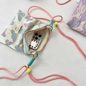 Detail showing the inner capacity of butterfly crossbody bag with a smartphone inside
