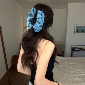 Rear view of model wearing a large light blue denim bow hair claw clip for a stylish updo