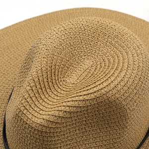 Close-up of tightly woven texture and brown ribbon on khaki straw sun hat