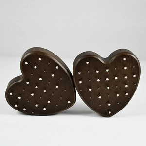 Detail of heart-shaped dark wood display stand with decorative metal stud inlay