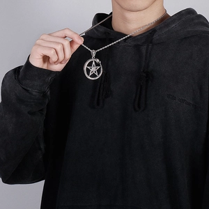 Macro detail of gothic pentagram pendant with snake ring on silver twisted chain