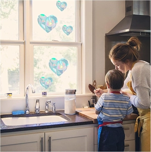 Rainbow prism heart window stickers creating colorful suncatcher effects in a cozy kitchen