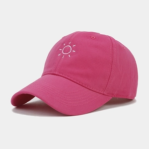 Close-up of pink baseball cap with white sun embroidery and fine cotton twill texture