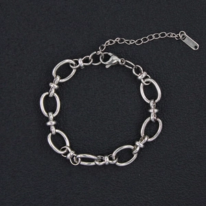 Detail of silver chain bracelet showing oval links, lobster clasp, and extension chain