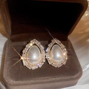 Détail de boucles d'oreilles vintage avec pierres œil de chat dans un écrin