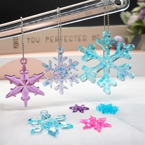 Sparkling snowflake pendants in purple and blue resin with metal chains for Christmas decor